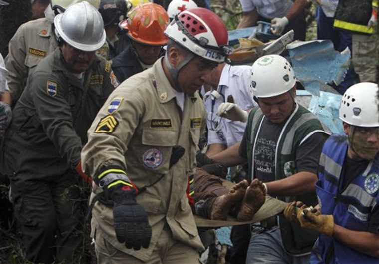 Rescue workers remove bodies from the wreckage of a small commercial airplane after it crashed Monday near the town of Las Mesitas on the outskirts of the capital city of Tegucigalpa, Honduras.
